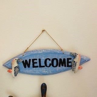 Decorative wooden welcome sign with pelican