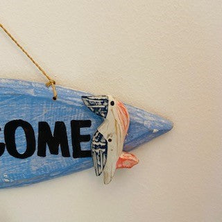 Decorative wooden welcome sign with pelican