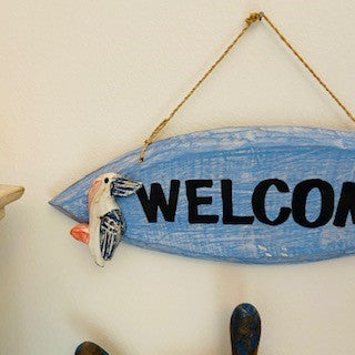 Decorative wooden welcome sign with pelican
